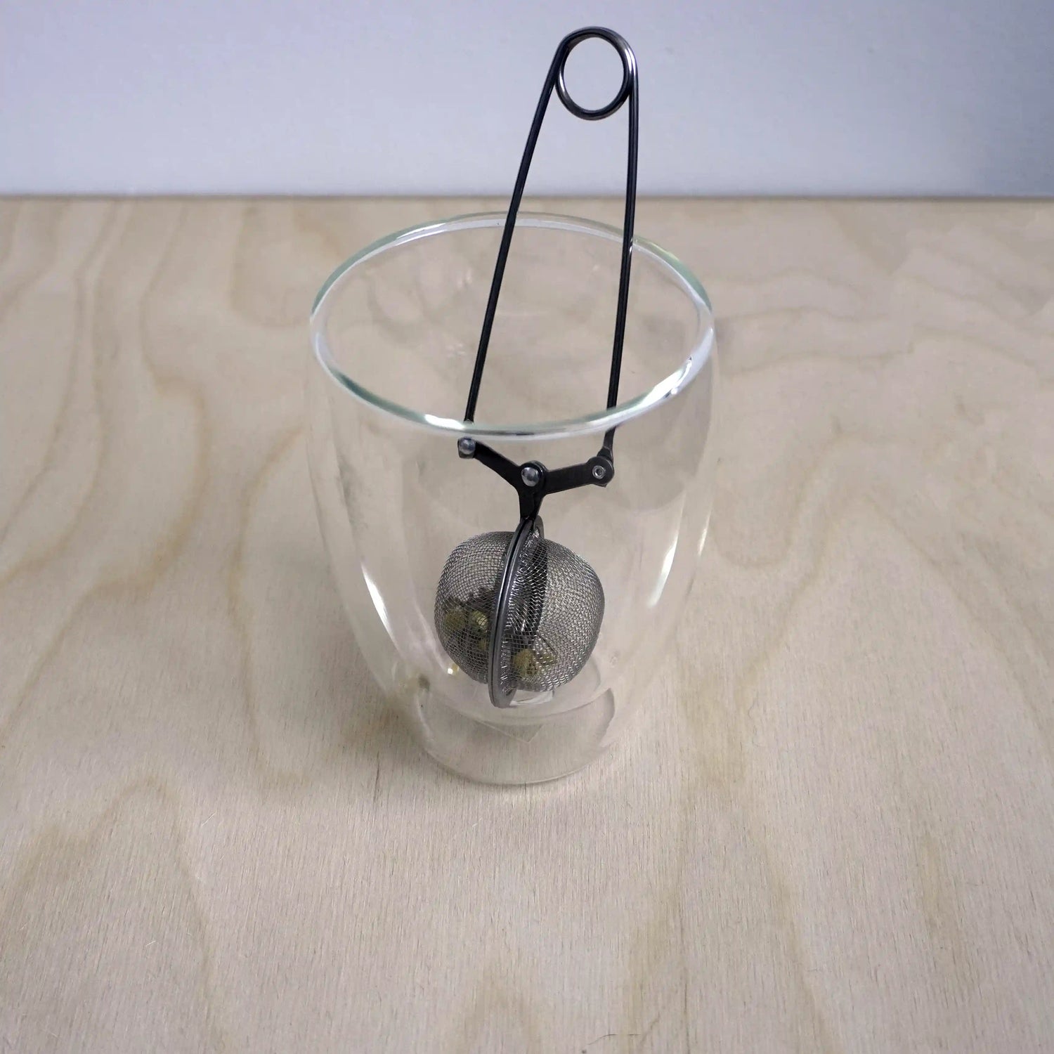 Vooraanzicht van een theefilter met klem functie in een glas