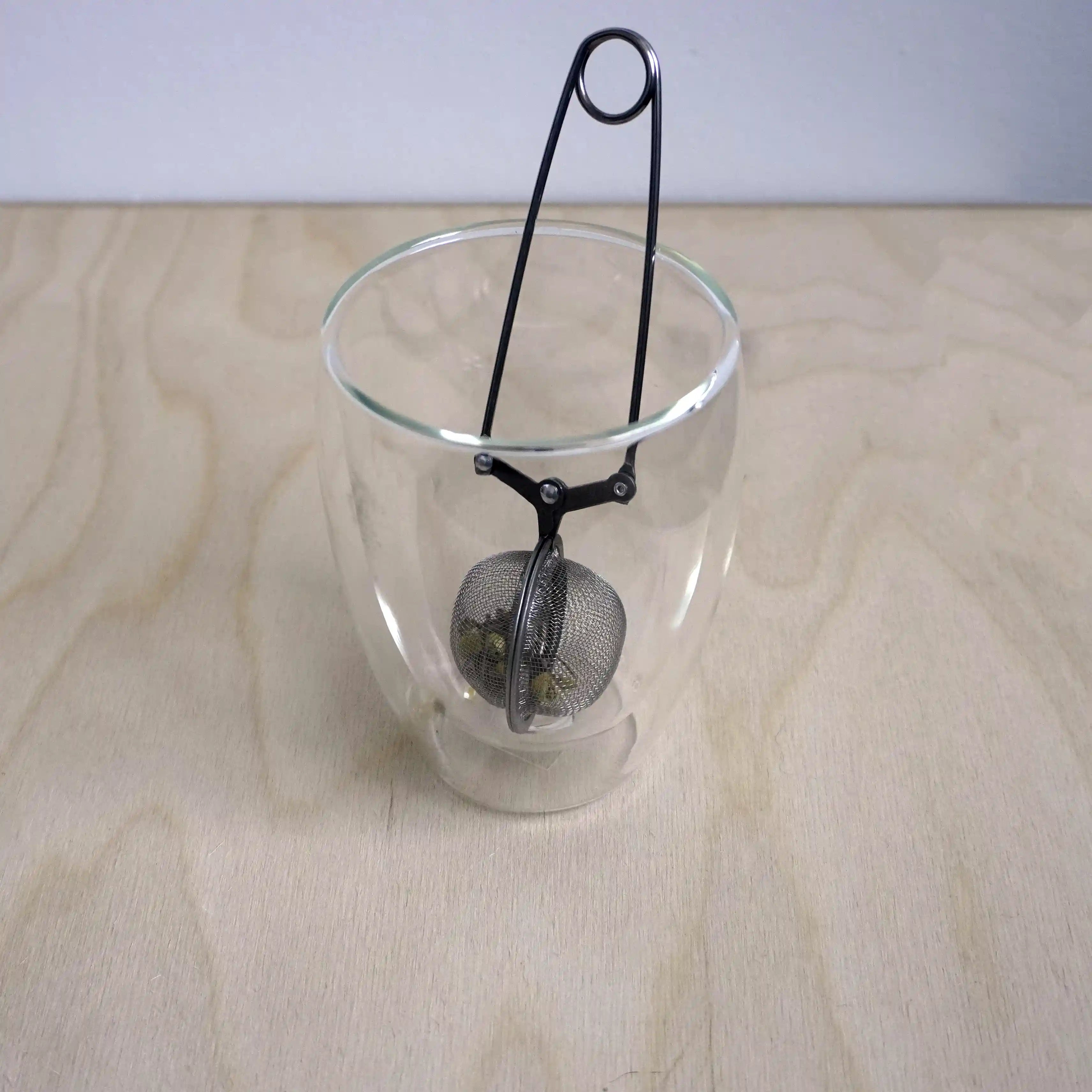Vooraanzicht van een theefilter met klem functie in een glas