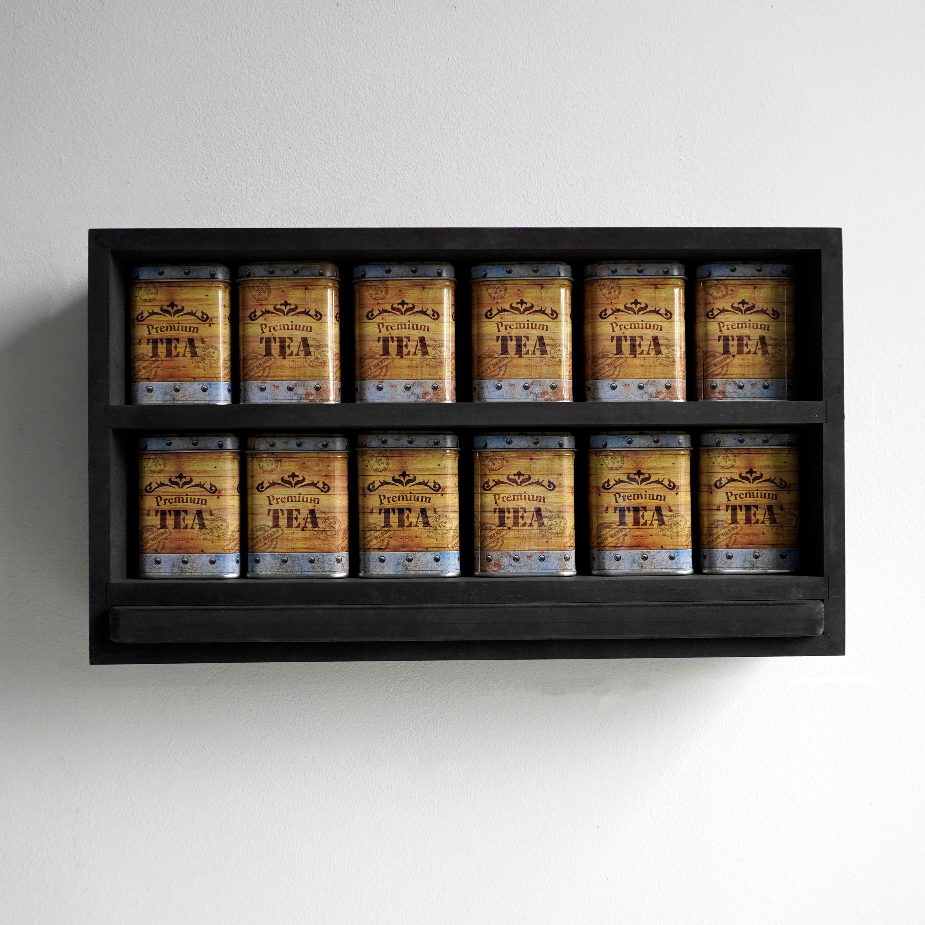 Vooraanzicht van een theerek met tea chest blikken en zwarte serveerplank