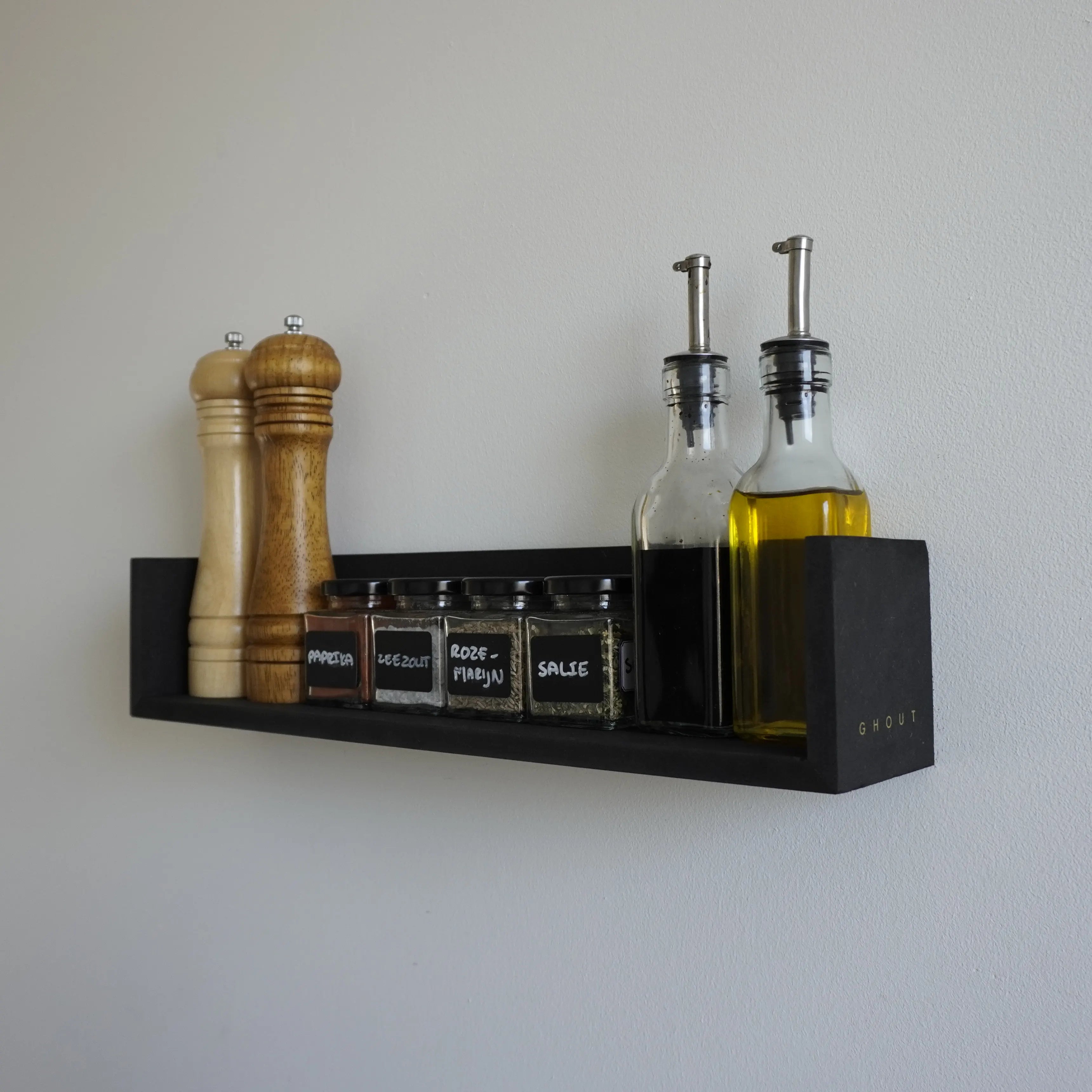 Zij aanzicht van een zwevende wandplank met opstaande randen aan de zijkant in een zwarte kleur. Op de plank staan diverse kruidenpotjes, olieflesjes en een peper- en zoutmolen.